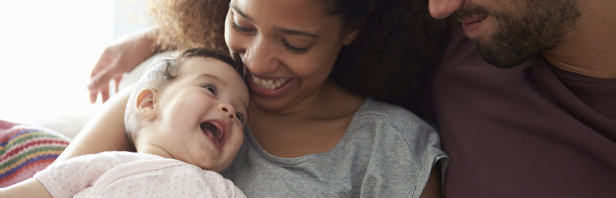 Mother and father smiling at their baby