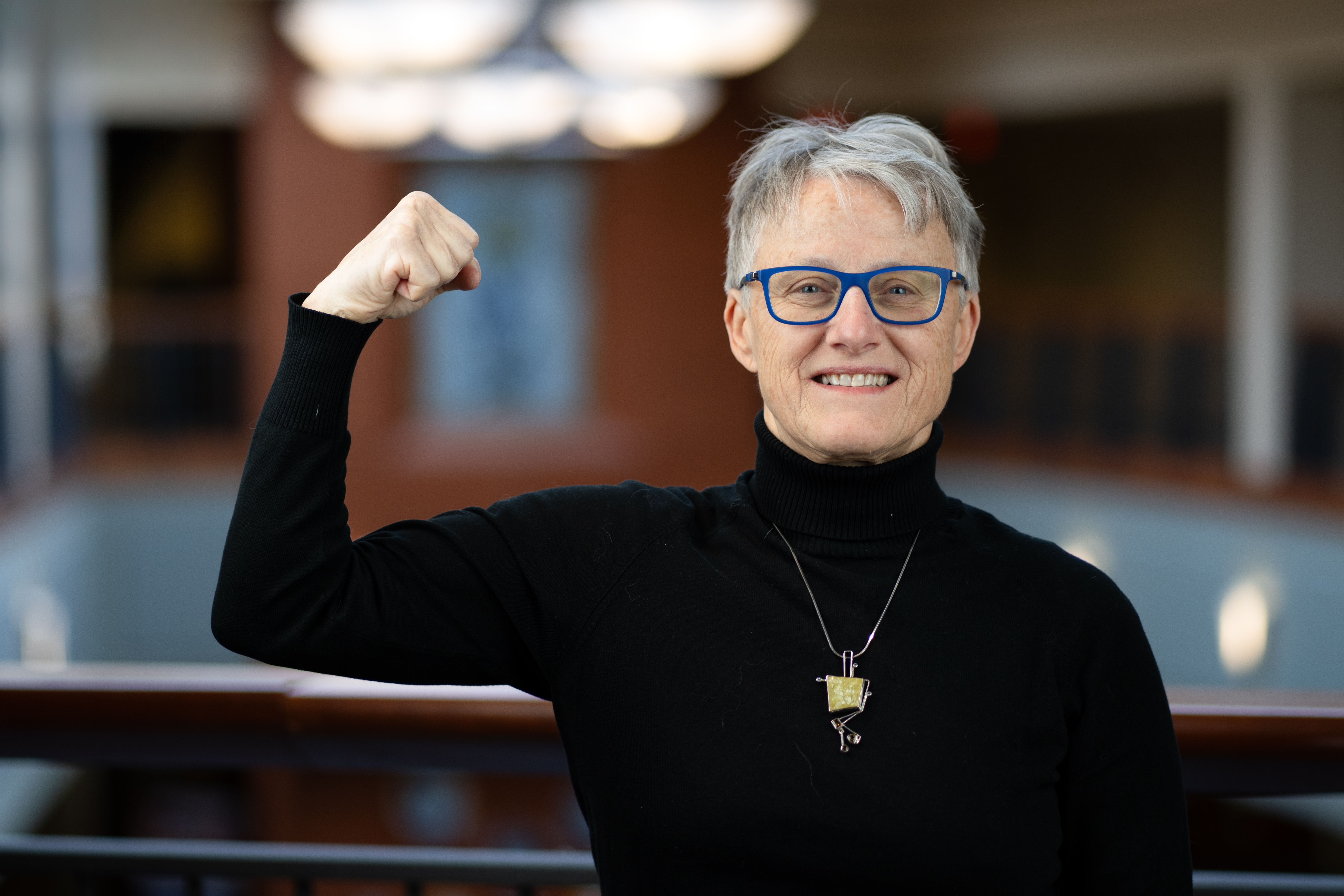 Dr. Maria Muzik flexing her arm and smiling.