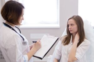 Distressed teen patient listens to her doctor.