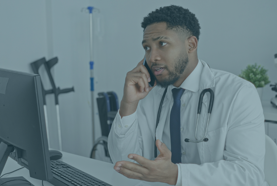 Doctor sits in his office talking on the phone.